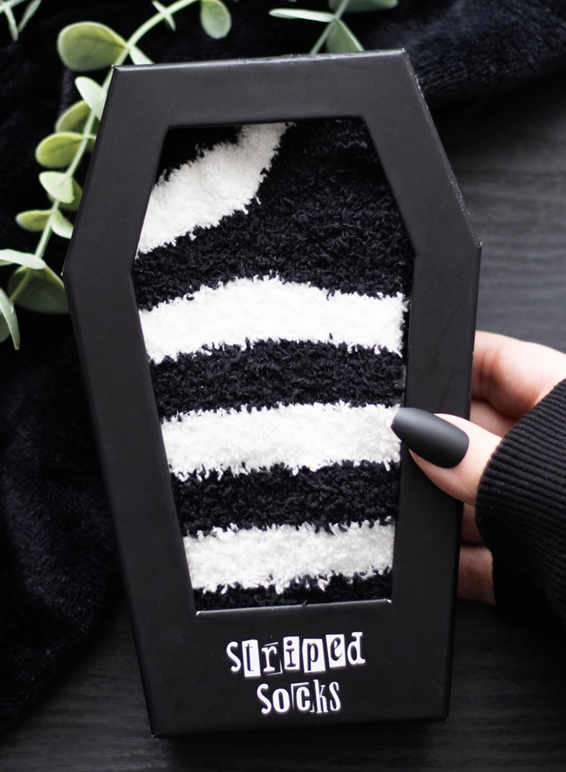 Betel Juice Coffin Socks. Fluffy black and white striped emo socks in a coffin-shaped gift box from Something Different. Soft gothic socks in alternative style.